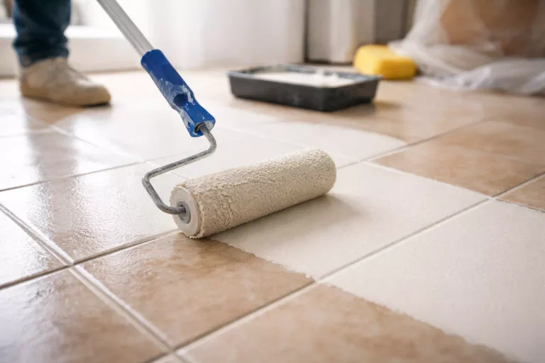 Peindre un carrelage de sol avec un rouleau pour rénover un intérieur sans gros travaux